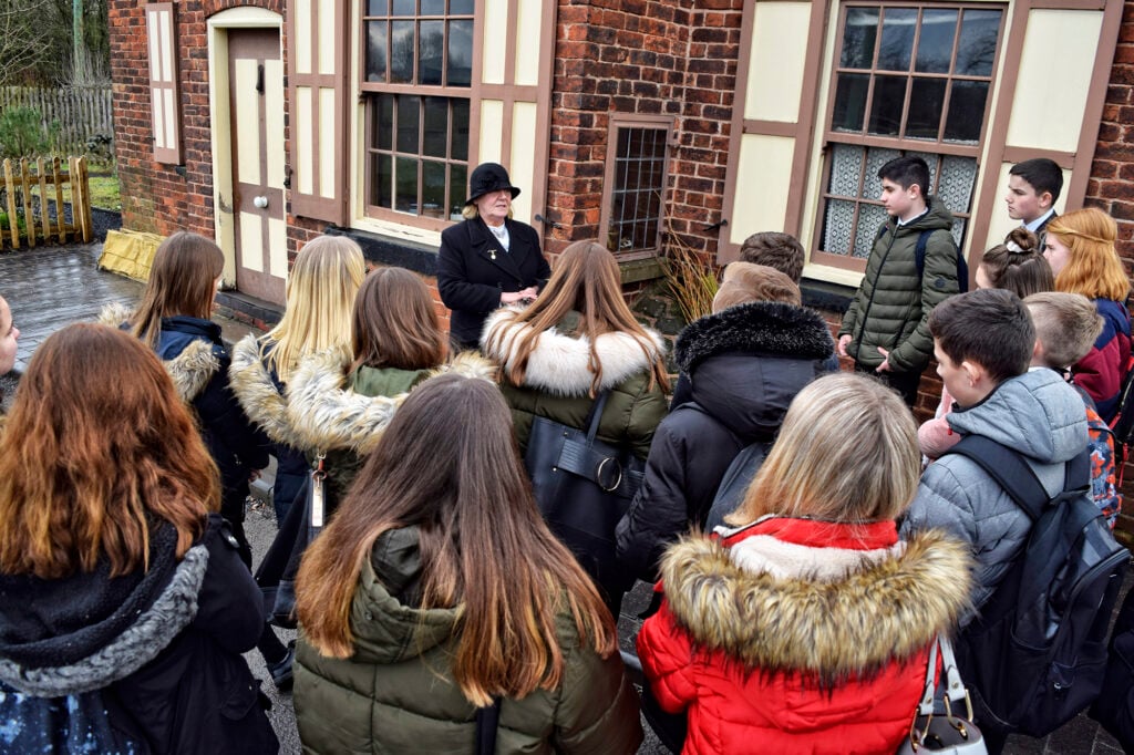 Key Stage 3 or 4  Students enjoying a guided tour of the Museum Toll House